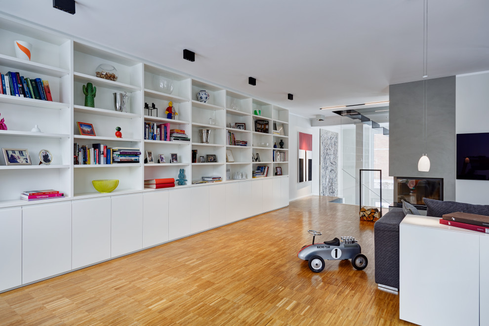 Großes Modernes Wohnzimmer mit weißer Wandfarbe, braunem Holzboden, Eckkamin, Kaminumrandung aus Beton, TV-Wand und braunem Boden in Düsseldorf
