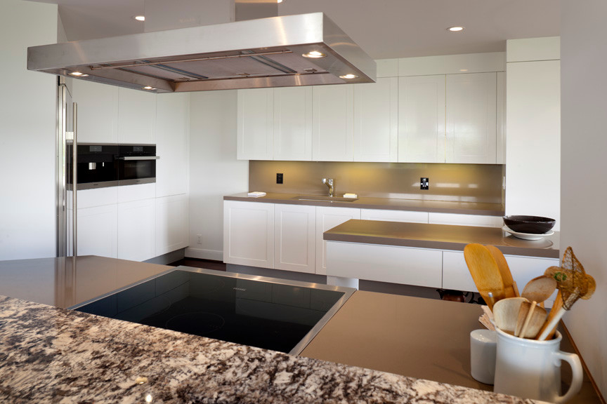 Eat-in kitchen - mid-sized modern galley medium tone wood floor eat-in kitchen idea in Houston with an undermount sink, flat-panel cabinets, white cabinets, solid surface countertops, brown backsplash, stone slab backsplash, stainless steel appliances and an island