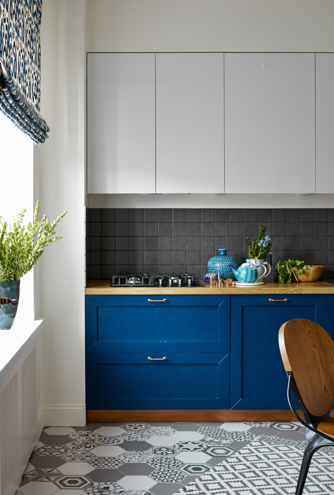 Inspiration for a transitional kitchen in Moscow with recessed-panel cabinets, black splashback and blue cabinets.