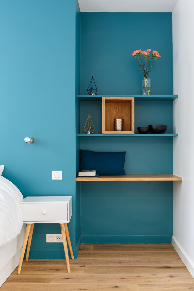 Inspiration for a mid-sized modern master bedroom in Paris with blue walls, medium hardwood floors, no fireplace and brown floor.