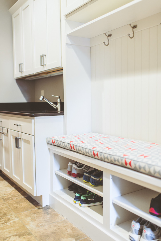 Inspiration for a mid-sized contemporary limestone floor mudroom remodel with white walls