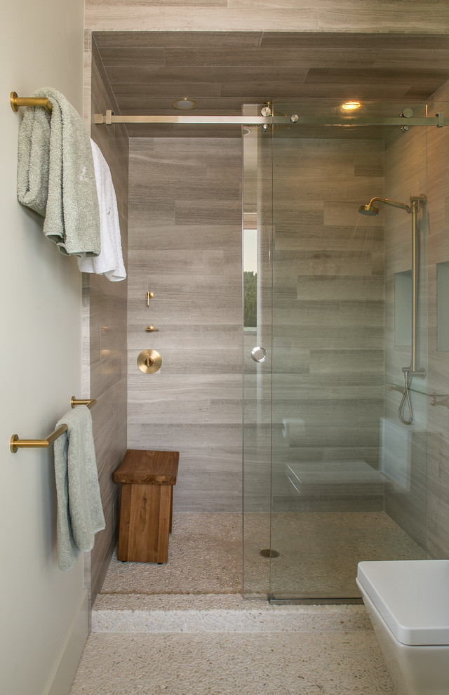 Photo of a small contemporary bathroom in Seattle with open cabinets, an alcove shower, a one-piece toilet, beige tile, green walls and pebble tile floors.