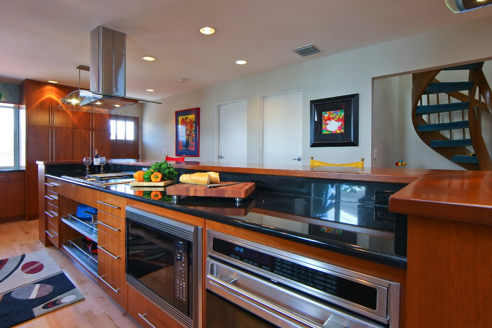 Eat-in kitchen - large transitional l-shaped light wood floor eat-in kitchen idea with flat-panel cabinets, medium tone wood cabinets, wood countertops, stainless steel appliances and an island