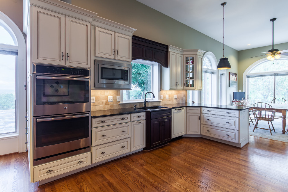 Example of a huge transitional medium tone wood floor eat-in kitchen design in DC Metro with raised-panel cabinets, granite countertops, stainless steel appliances and an island