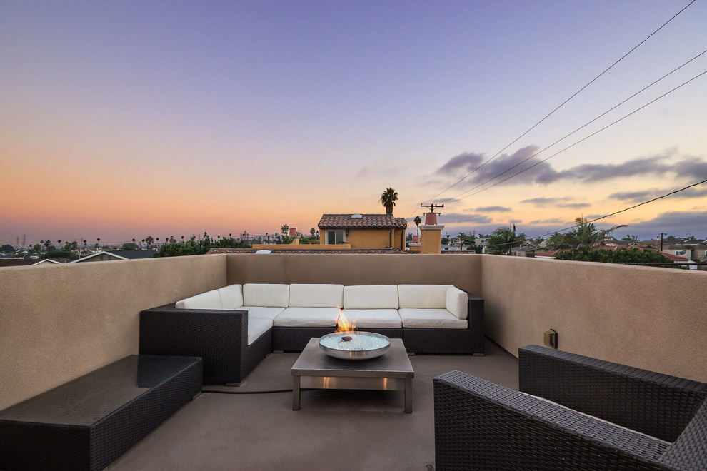 Photo of a mid-sized mediterranean rooftop deck in Los Angeles with a fire feature and no cover.