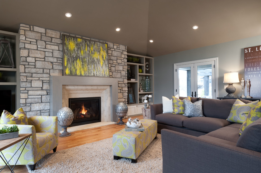 Photo of a transitional living room in St Louis with a standard fireplace and a stone fireplace surround.