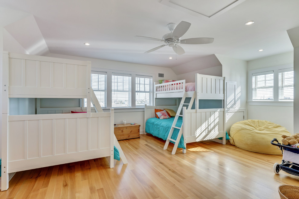 Inspiration for a large beach style gender-neutral kids' bedroom in New York with white walls and light hardwood floors.