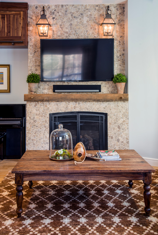 Inspiration for a mid-sized country open concept family room in Burlington with blue walls, carpet, a standard fireplace, a stone fireplace surround, a wall-mounted tv and multi-coloured floor.