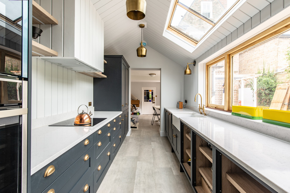 Inspiration for a transitional galley eat-in kitchen in Kent with a farmhouse sink, recessed-panel cabinets, grey cabinets, quartzite benchtops, white splashback, black appliances, no island and white benchtop.