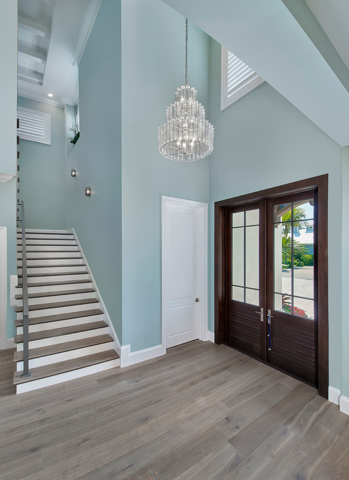 Beach style foyer in Miami with a double front door and a dark wood front door.
