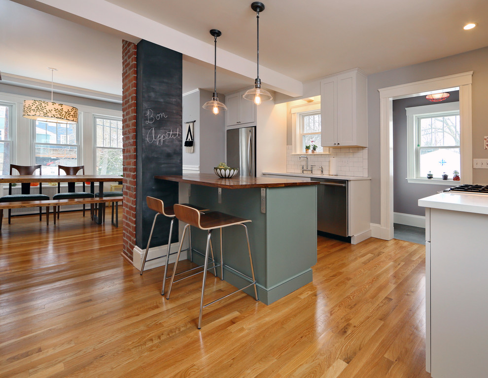 Photo of a small contemporary u-shaped kitchen in Boston with an undermount sink, shaker cabinets, green cabinets, wood benchtops, white splashback, subway tile splashback, stainless steel appliances, medium hardwood floors and with island.