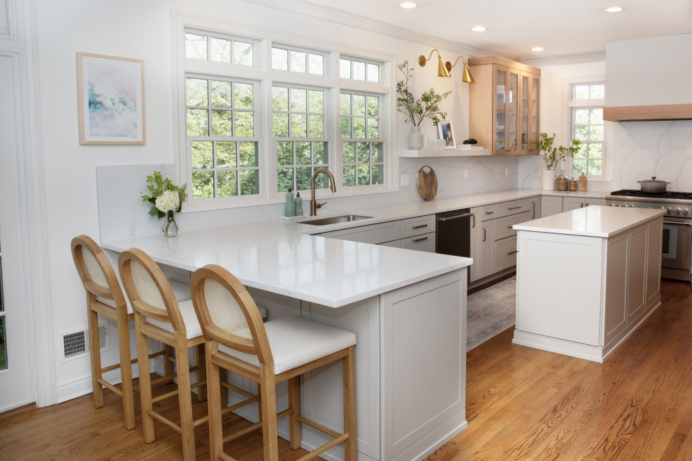 Eat-in kitchen - large transitional l-shaped medium tone wood floor and brown floor eat-in kitchen idea in New York with an undermount sink, shaker cabinets, gray cabinets, quartz countertops, white backsplash, quartz backsplash, stainless steel appliances, an island and white countertops