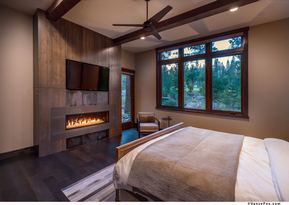 Design ideas for a mid-sized modern guest bedroom in Sacramento with beige walls, dark hardwood floors, a metal fireplace surround and a ribbon fireplace.