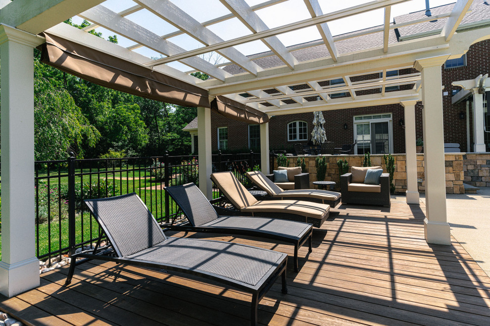 Photo of a traditional backyard and ground level deck in Columbus with with privacy feature, a pergola and metal railing.