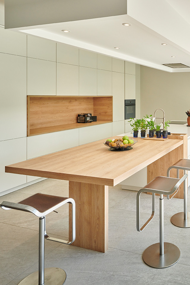 Пример оригинального дизайна: прямая кухня в современном стиле с обеденным столом, плоскими фасадами, серыми фасадами и островом