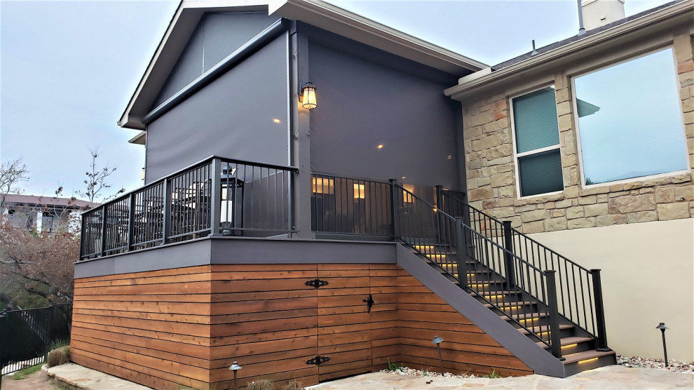 Inspiration for a large rustic backyard second story metal railing deck remodel in Austin with a roof extension