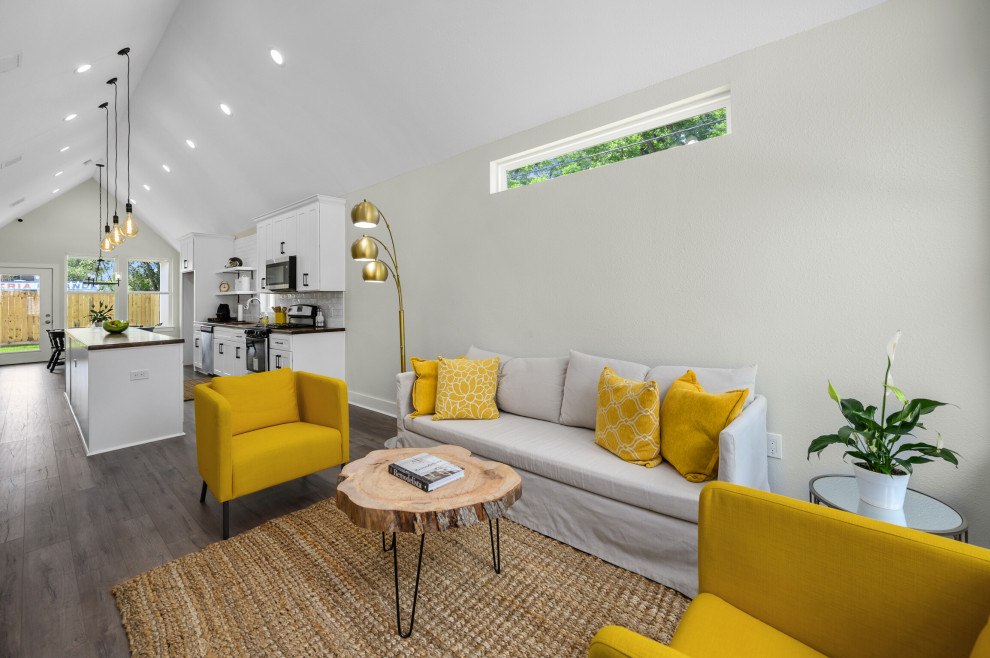 Imagen de salón para visitas abierto y abovedado moderno de tamaño medio con paredes grises, suelo laminado, televisor colgado en la pared y suelo gris