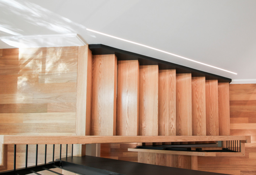 Photo of a large contemporary wood u-shaped staircase in DC Metro with mixed railing.