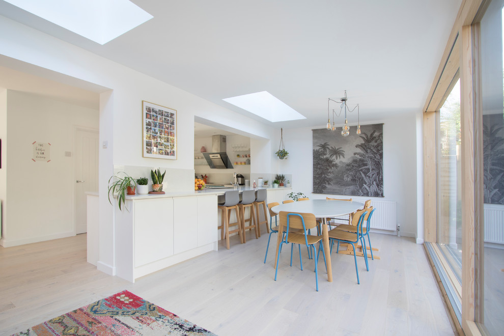 Inspiration for a large contemporary open plan dining in Gloucestershire with white walls, light hardwood floors and beige floor.