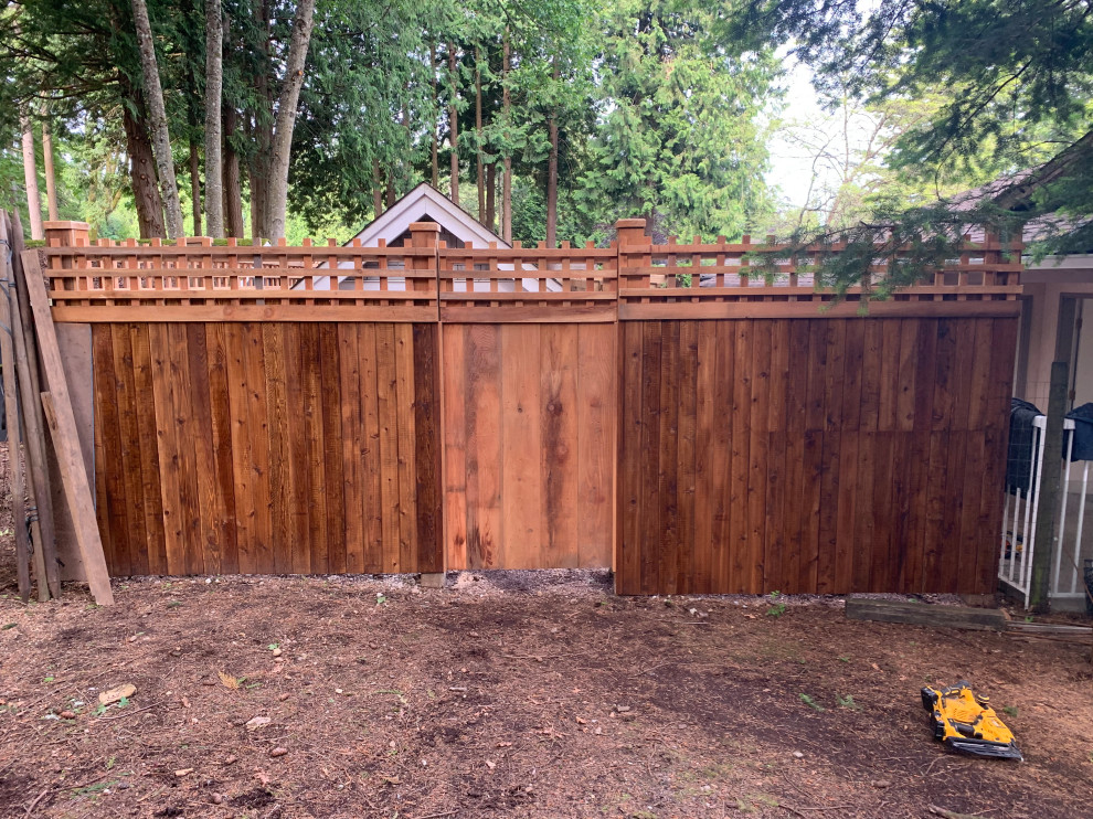 Immagine di un ampio privacy in giardino american style dietro casa con recinzione in legno