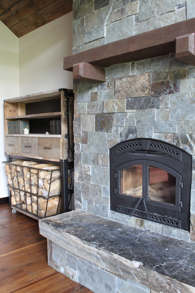 Example of a mountain style home design design with a standard fireplace and a stone fireplace