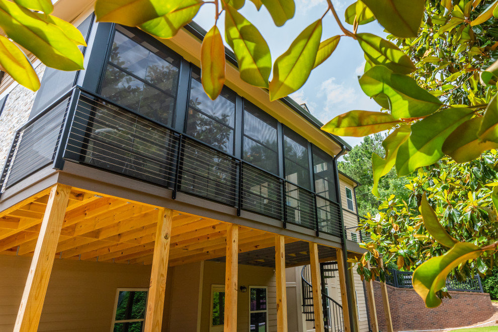 Modelo de terraza minimalista de tamaño medio en patio trasero y anexo de casas con chimenea y barandilla de cable
