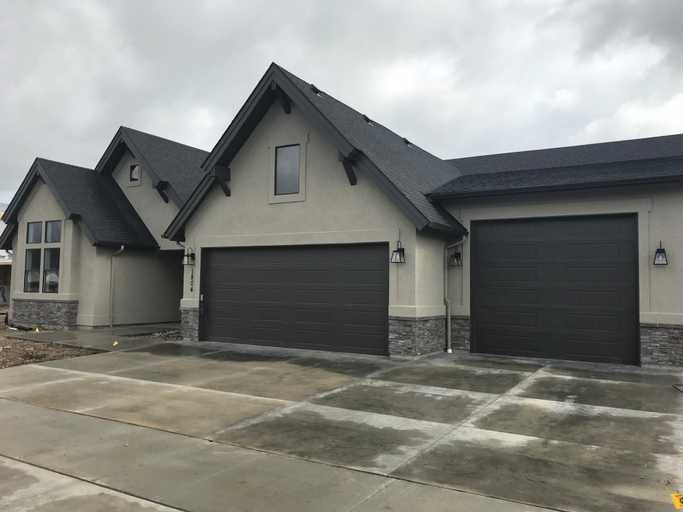 Inspiration for a mid-sized transitional beige one-story stucco gable roof remodel in Boise with a shingle roof