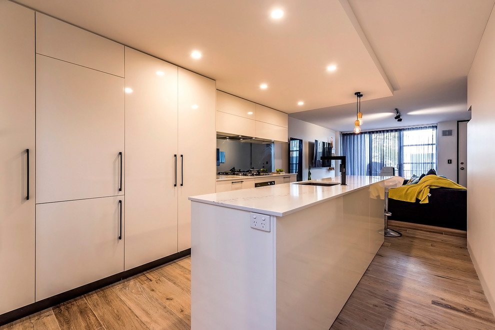 Design ideas for a mid-sized contemporary kitchen in Perth with an undermount sink, flat-panel cabinets, white cabinets, quartz benchtops, mirror splashback, porcelain floors and with island.