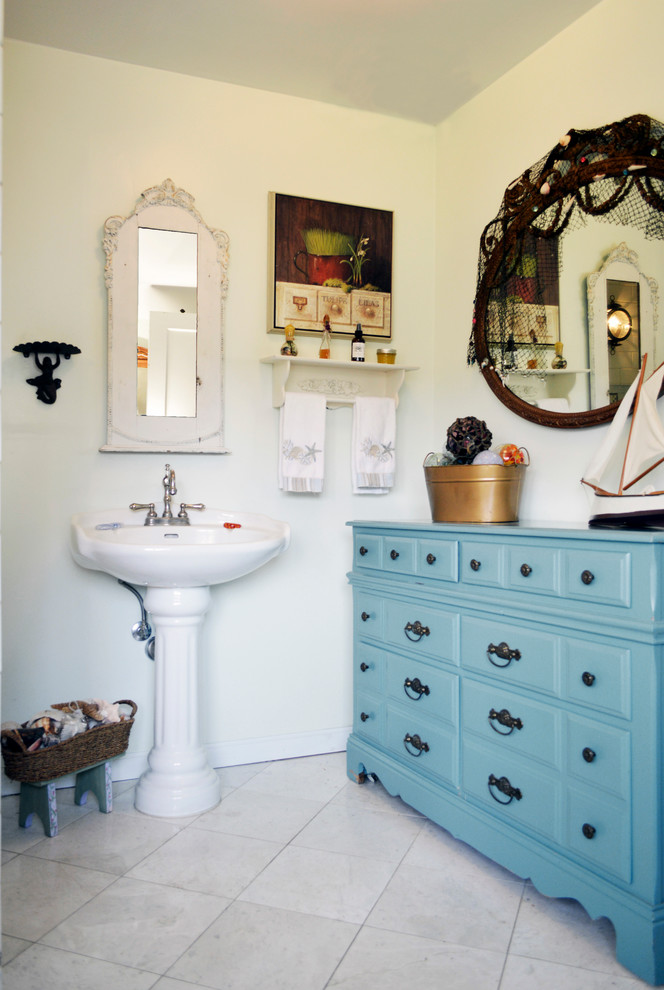 Photo of a mid-sized beach style master bathroom in Seattle with furniture-like cabinets, blue cabinets, an open shower, white tile, ceramic tile and a pedestal sink.
