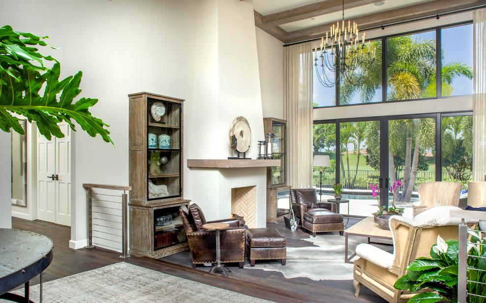 Tropical living room in Tampa with beige walls, dark hardwood floors and a standard fireplace.