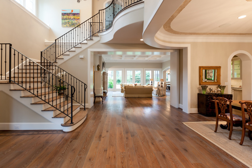 Example of a large transitional medium tone wood floor foyer design in Houston with beige walls