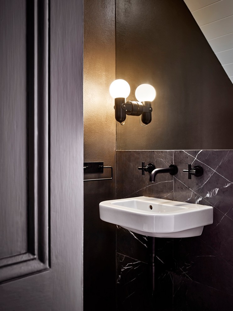 This is an example of an industrial powder room in Sydney with a wall-mount sink, black tile and black walls.