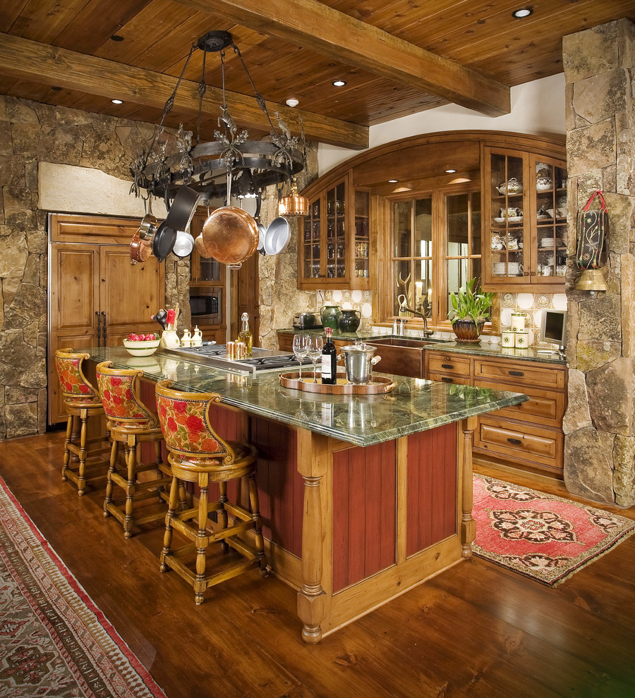 Design ideas for a country l-shaped kitchen in Other with a farmhouse sink, raised-panel cabinets, medium wood cabinets, beige splashback, panelled appliances, medium hardwood floors, with island, brown floor and green benchtop.