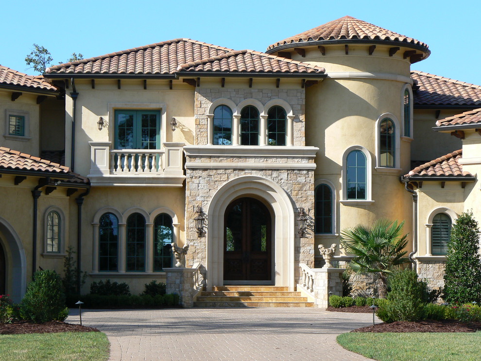 Photo of a large mediterranean two-storey exterior in Charlotte with a hip roof.