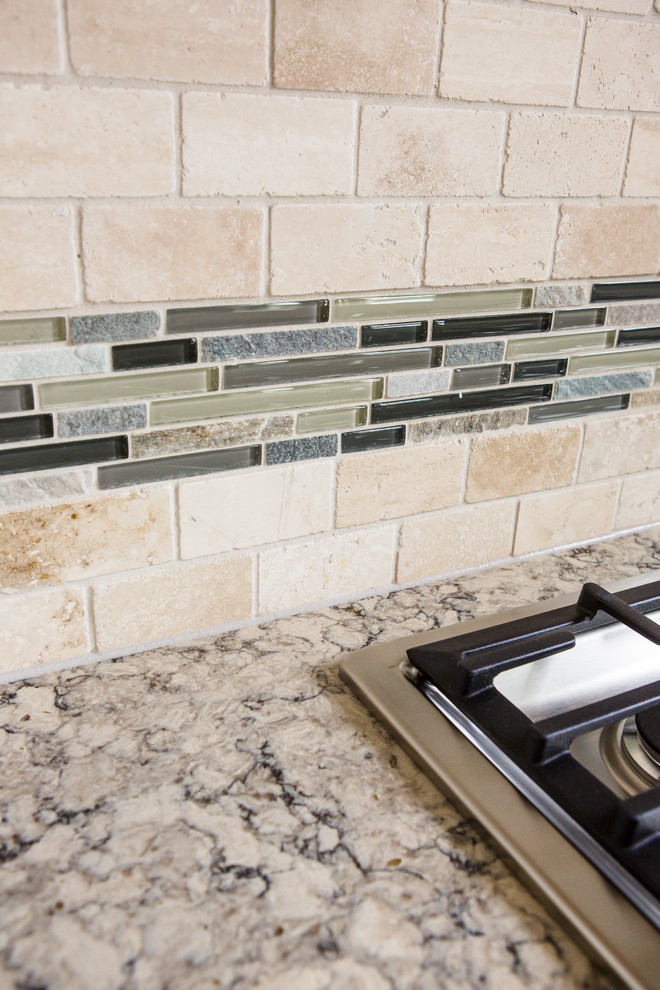 Eat-in kitchen - mid-sized transitional l-shaped medium tone wood floor eat-in kitchen idea in Austin with an undermount sink, recessed-panel cabinets, white cabinets, granite countertops, beige backsplash, stone tile backsplash, stainless steel appliances and an island