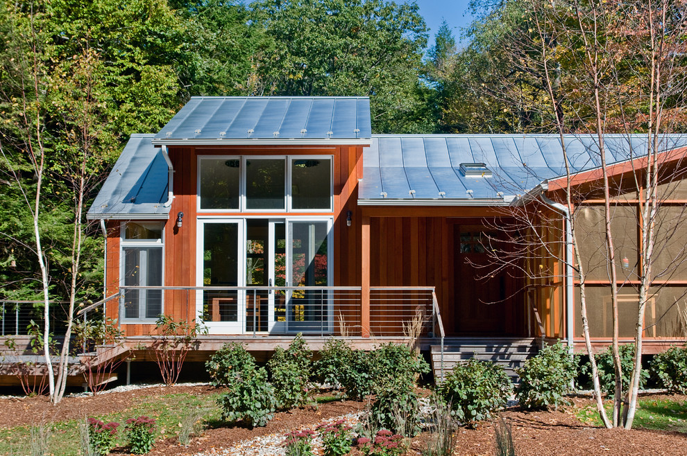 Large contemporary one-storey brown house exterior in Boston with wood siding, a gable roof and a metal roof.
