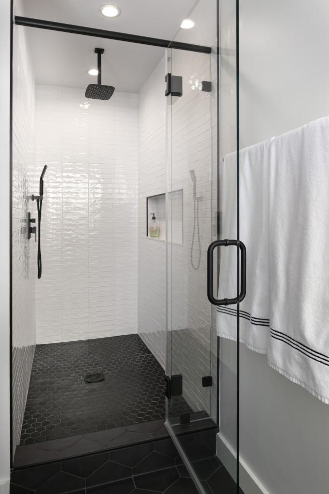 Inspiration for a medium sized classic ensuite bathroom in Los Angeles with flat-panel cabinets, medium wood cabinets, an alcove shower, a two-piece toilet, white tiles, metro tiles, white walls, porcelain flooring, a submerged sink, marble worktops, black floors, a hinged door, white worktops, an enclosed toilet, double sinks and a freestanding vanity unit.