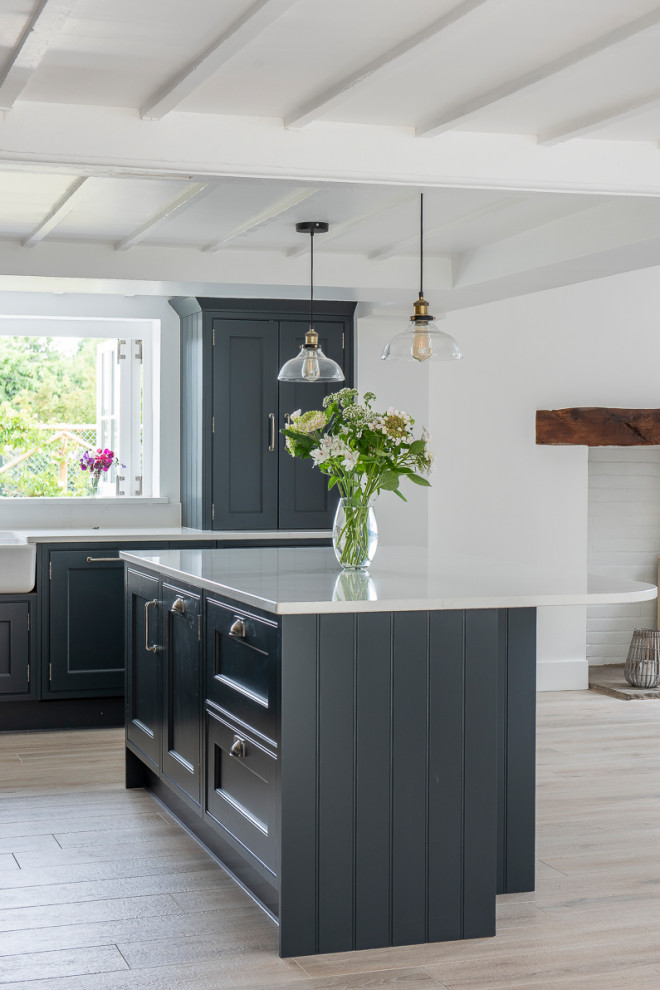 Transitional kitchen in Kent with dark wood cabinets, brick splashback and with island.