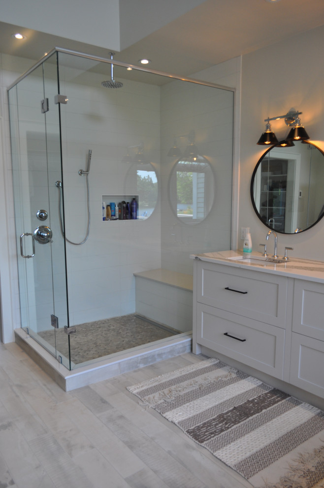 Photo of a mid-sized arts and crafts master wet room bathroom in Toronto with flat-panel cabinets, grey cabinets, a one-piece toilet, white tile, subway tile, white walls, ceramic floors, an integrated sink, engineered quartz benchtops, a hinged shower door, white benchtops, a double vanity and a floating vanity.