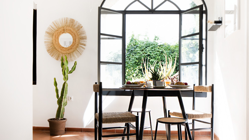 Imagen de comedor abovedado clásico renovado de tamaño medio cerrado con paredes blancas, suelo de baldosas de terracota y suelo marrón