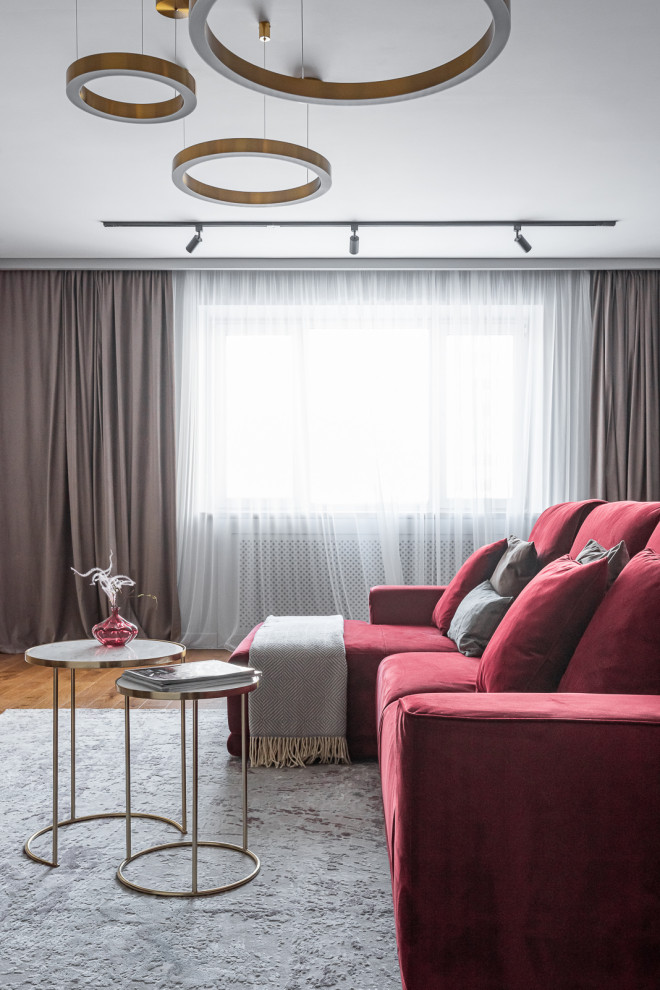 Свежая идея для дизайна: серо-белая гостиная комната среднего размера в современном стиле с серыми стенами, паркетным полом среднего тона, телевизором на стене, коричневым полом и бордовым диваном без камина - отличное фото интерьера