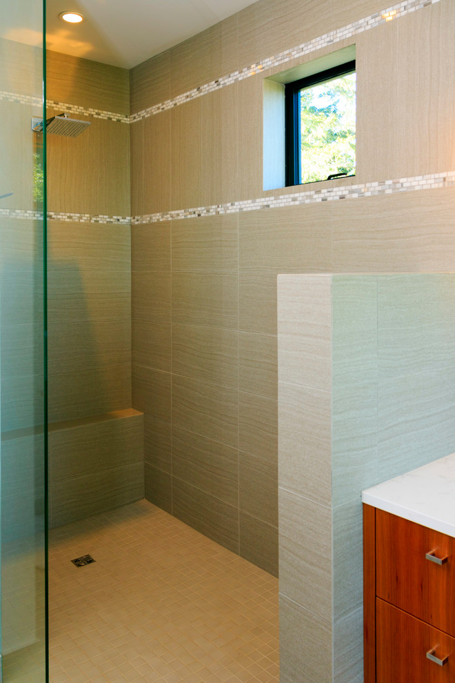 This is an example of a mid-sized contemporary master bathroom in Vancouver with flat-panel cabinets, medium wood cabinets, a drop-in tub, a corner shower, beige tile, white tile, glass tile, white walls, porcelain floors, an undermount sink and marble benchtops.