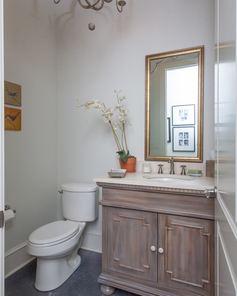Design ideas for a mid-sized country powder room in Little Rock with furniture-like cabinets, beige cabinets, a two-piece toilet, white walls, concrete floors, an undermount sink, grey floor and white benchtops.