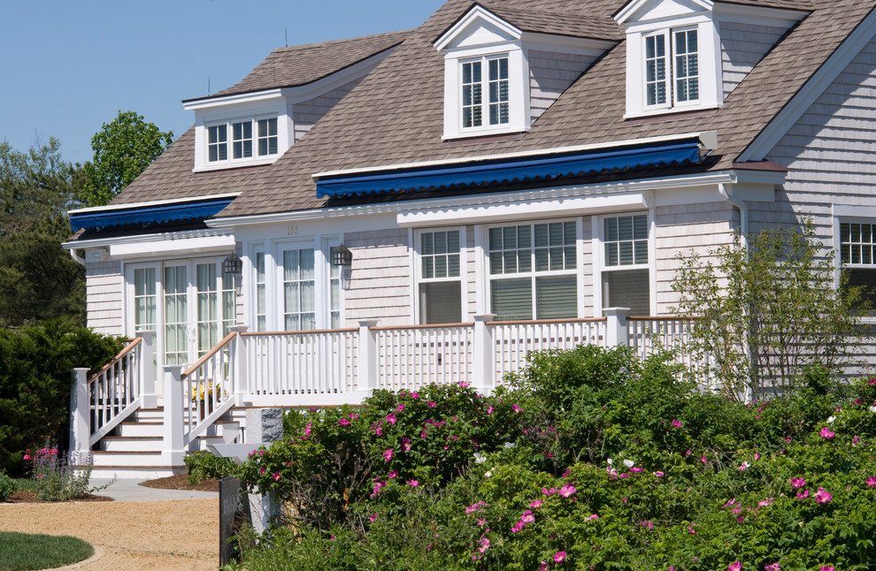 Photo of a mid-sized beach style three-storey beige exterior in Portland with wood siding.