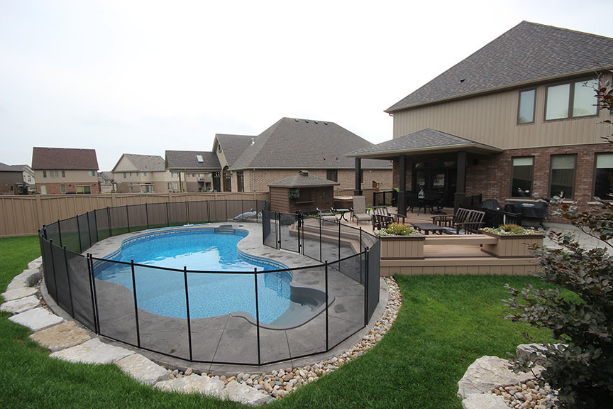This is an example of a large mediterranean backyard custom-shaped pool in Toronto with decking.