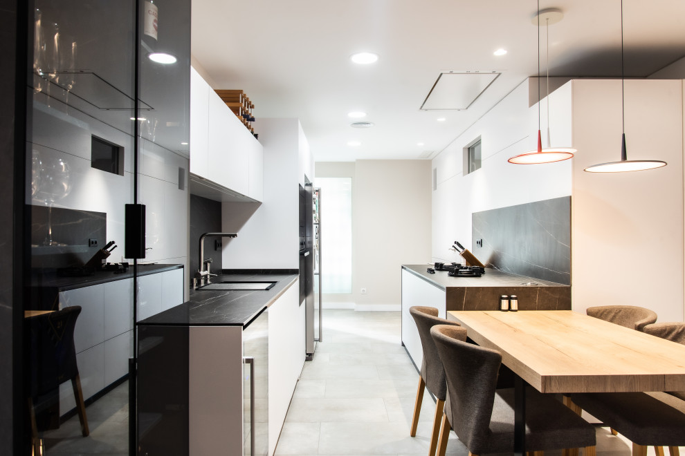 Источник вдохновения для домашнего уюта: большая отдельная, параллельная кухня в современном стиле с одинарной мойкой, стеклянными фасадами, черными фасадами, черным фартуком, островом и серой столешницей