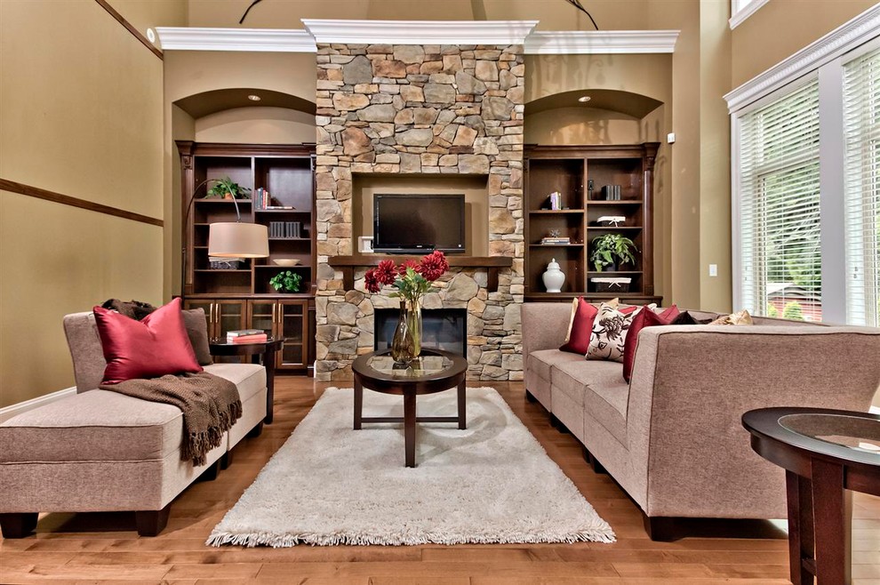 This is an example of a traditional living room in Other with a standard fireplace, a stone fireplace surround and a wall-mounted tv.