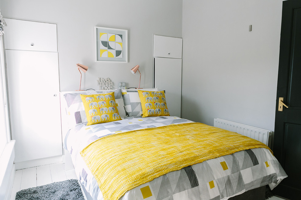 Example of a danish painted wood floor and white floor bedroom design in Dublin with white walls