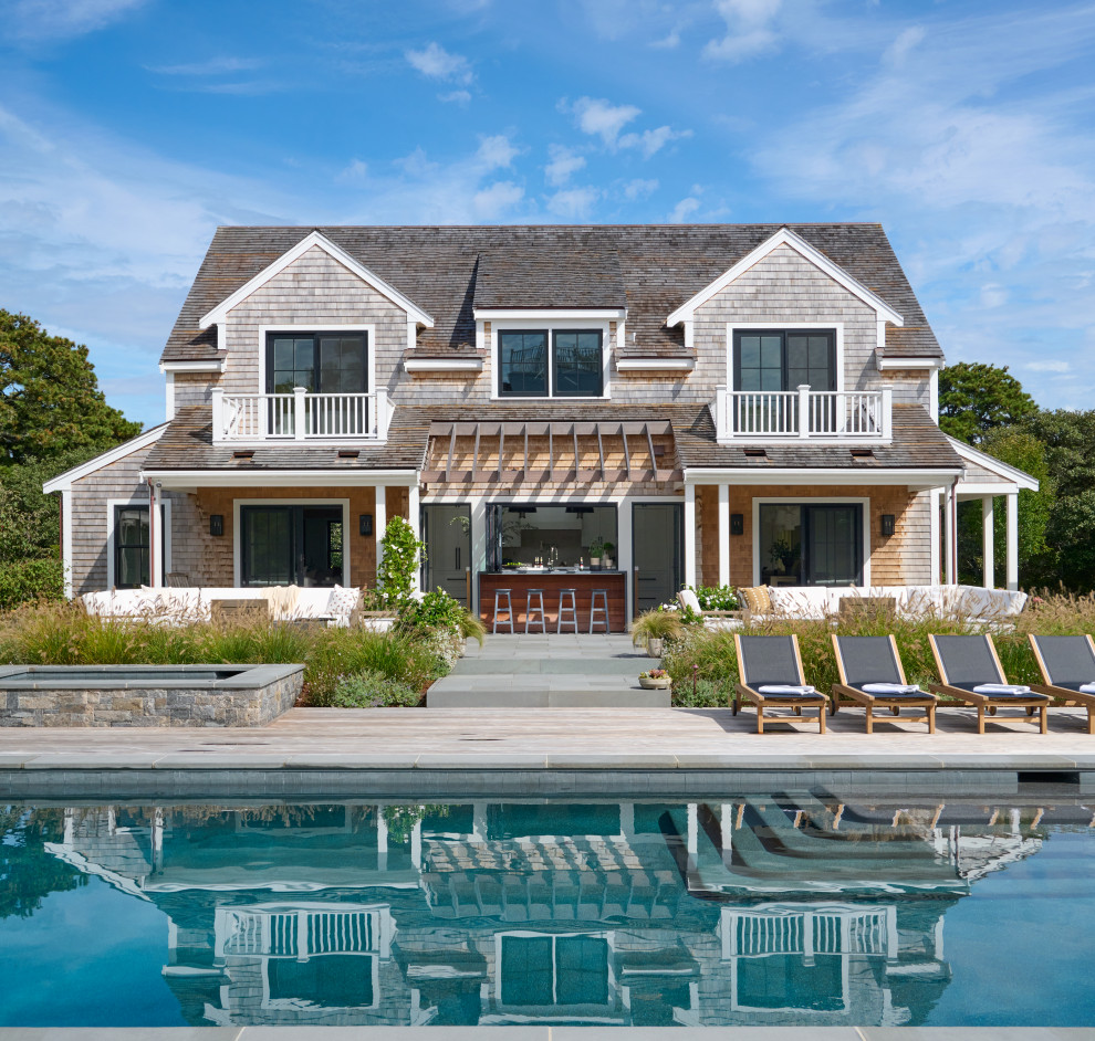 Beach style beige two-story wood and shingle exterior home photo in Boston with a shingle roof and a brown roof