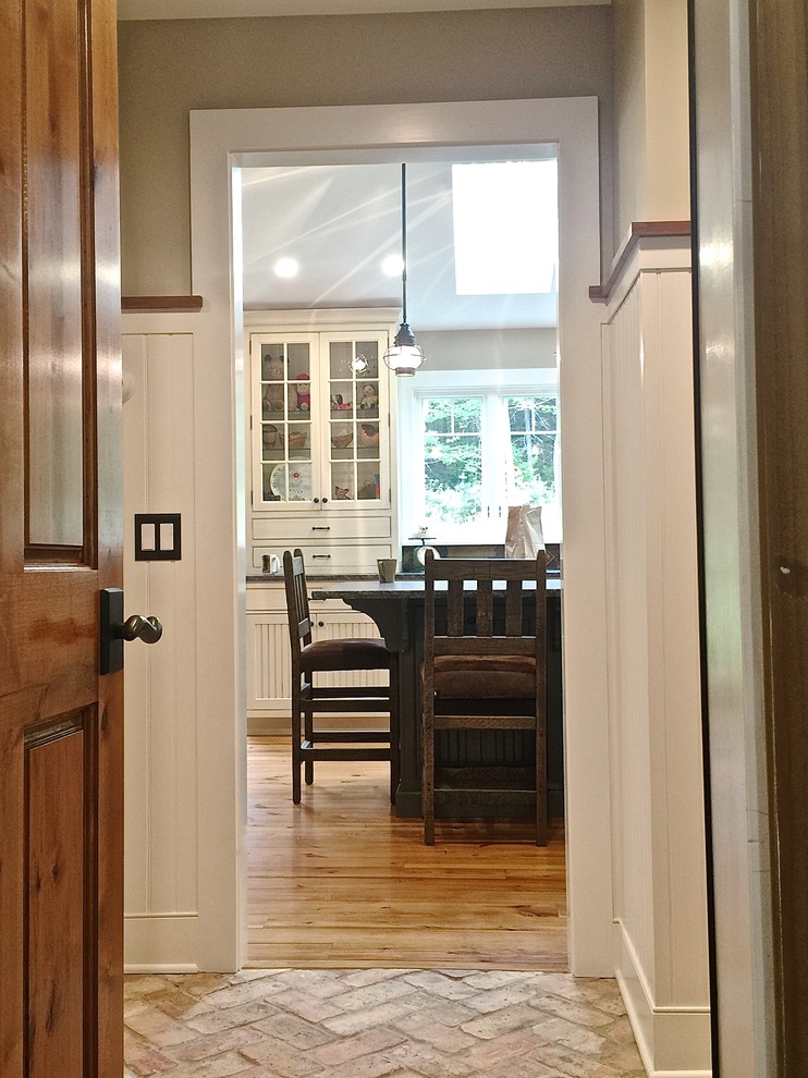 This is an example of a mid-sized transitional mudroom in Burlington with beige walls, brick floors, a single front door and a dark wood front door.